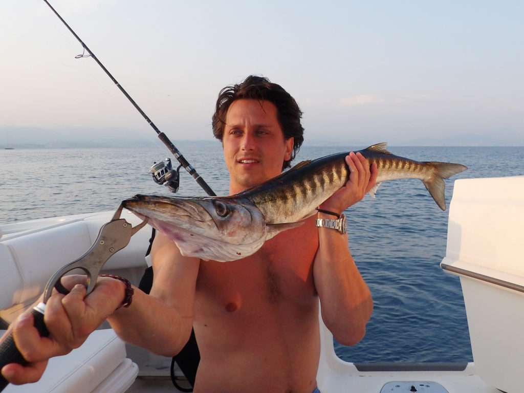Beau barracuda tenu avec le fish grip scale luxe par un client du guide de pêche Fabien Harbers